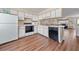 Bright kitchen featuring white cabinets, modern appliances, and durable wood-look flooring at 613 S 2Nd Ave. # 21D, North Myrtle Beach, SC 29582
