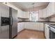 Modern kitchen featuring stainless steel refrigerator and white cabinets, seamlessly connecting to living area at 618 5Th Ave. S, North Myrtle Beach, SC 29582
