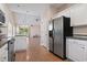 Open-concept kitchen with stainless steel appliances, white cabinets, and a clear view into the living area at 618 5Th Ave. S, North Myrtle Beach, SC 29582