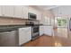 Bright kitchen features white cabinets, stainless steel appliances, and wood flooring at 618 5Th Ave. S, North Myrtle Beach, SC 29582