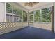 Relaxing screened-in porch with a ceiling fan and blue carpeting, perfect for enjoying the outdoors at 618 5Th Ave. S, North Myrtle Beach, SC 29582