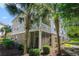 Apartment building exterior with lush landscaping, palm trees, and private screened-in porch at 6253 Catalina Dr. # 1523, North Myrtle Beach, SC 29582