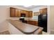 Kitchen with wooden cabinets and black appliances next to a stone countertop at 6253 Catalina Dr. # 1523, North Myrtle Beach, SC 29582