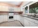 White kitchen featuring a large window, ample cabinetry, and modern appliances at 6813 Porcher Dr. # 1, Myrtle Beach, SC 29572