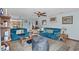 Cozy living room with blue couches, ceiling fan, and tile floors, flowing into the kitchen at 6813 Porcher Dr. # 25, Myrtle Beach, SC 29572