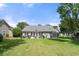 Expansive backyard featuring a patio, lush green grass, and mature trees at 6887 King Arthur Dr., Myrtle Beach, SC 29588