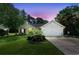 Charming single-story home with brick accents, two car garage, and lush landscaping at dusk at 6887 King Arthur Dr., Myrtle Beach, SC 29588