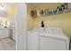 Convenient laundry room featuring a washer, dryer, and storage shelves at 6887 King Arthur Dr., Myrtle Beach, SC 29588