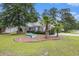 Well-maintained brick home featuring blue shutters, landscaped beds, and mature trees in a serene setting at 7007 Blade Beak Ln., Myrtle Beach, SC 29588