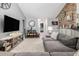 Open-concept living room with a stone accent wall, a large sectional sofa, and a view of the foyer at 7007 Blade Beak Ln., Myrtle Beach, SC 29588