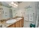 Bright bathroom featuring double sinks, granite countertops, and shower with tile surround at 702 Beach Walk Pl. # 702, Myrtle Beach, SC 29577