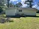 Home exterior features a small deck, lawn, and mature trees at 76 Lyerly Rd., Hemingway, SC 29554