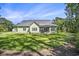 Green home exterior with a lush backyard and screened in porch at 769 Country Club Dr., Pawleys Island, SC 29585