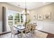 Elegant dining room with a chandelier, wainscoting, a large window, and views of the backyard pond at 769 Country Club Dr., Pawleys Island, SC 29585