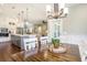 Bright dining area featuring a modern chandelier, white wainscoting, and views into kitchen and living room at 769 Country Club Dr., Pawleys Island, SC 29585