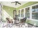 Inviting screened porch with wicker furniture, ceiling fan, and green exterior at 769 Country Club Dr., Pawleys Island, SC 29585