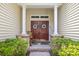 Charming front porch with double doors, a rocking chair, and stone accents offering a warm welcome at 86 Wickham Ct., Pawleys Island, SC 29585