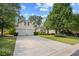 Well-maintained home featuring a long driveway, verdant lawn, mature trees, and a two-car garage at 86 Wickham Ct., Pawleys Island, SC 29585