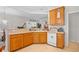 Kitchen with wooden cabinets and white dishwasher open to adjoining rooms at 86 Wickham Ct., Pawleys Island, SC 29585