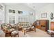 Bright living room featuring a wall of windows with plantation shutters and comfortable wicker furniture at 86 Wickham Ct., Pawleys Island, SC 29585