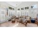 Sunroom with multiple windows and tile floor, offering ample natural light and comfortable wicker furniture at 86 Wickham Ct., Pawleys Island, SC 29585