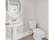 Bright half bath features a pedestal sink with a round mirror at 101 Culpepper Way # 1006, Myrtle Beach, SC 29579