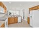 Efficient kitchen with white appliances, wooden cabinets, and view to the living areas at 101 Culpepper Way # 1006, Myrtle Beach, SC 29579