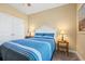 Comfortable bedroom featuring a queen bed with blue striped bedding and nightstands with lamps at 1025 Limpkin Dr., Conway, SC 29526