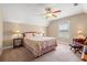 Well-lit bedroom featuring a queen bed, nightstands, lamps, ceiling fan, and comfortable seating at 1025 Limpkin Dr., Conway, SC 29526