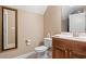 Powder room featuring a wooden vanity, modern fixtures, white toilet, and a framed mirror at 1025 Limpkin Dr., Conway, SC 29526