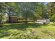 Expansive backyard with mature trees and a glimpse of the home's back exterior at 1043 South Main St., Aynor, SC 29511
