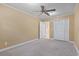 This bedroom has neutral walls, gray carpeting, a ceiling fan, and a closet at 1043 South Main St., Aynor, SC 29511