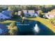 Aerial view of townhouses with a scenic pond and fountain, complemented by lush landscaping and mature trees at 107 Pawleys Place Dr. # 107, Pawleys Island, SC 29585