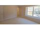 Bright bedroom with neutral carpet and paint, and a large window at 107 Pawleys Place Dr. # 107, Pawleys Island, SC 29585