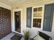 Inviting front porch with a horseshoe, decorative brick, and charming gray shutters beside a window at 107 Pawleys Place Dr. # 107, Pawleys Island, SC 29585