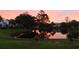 Beautiful community pond reflecting a colorful sunrise, with manicured lawn at 107 Pawleys Place Dr. # 107, Pawleys Island, SC 29585