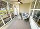 Cozy screened porch with wicker furniture, creating a relaxing outdoor retreat with views of the surrounding landscape at 107 Pawleys Place Dr. # 107, Pawleys Island, SC 29585