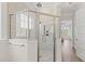 Shower with frameless glass enclosure, pebble floor, double shower heads, and view to the bedroom at 109 Serenity Point Dr., Little River, SC 29566
