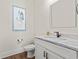 Powder room featuring a modern vanity with marble countertop, framed heron print, and wood tile flooring at 109 Serenity Point Dr., Little River, SC 29566