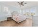 Light and airy main bedroom features a large window for lots of light, ceiling fan, and wood flooring at 109 Serenity Point Dr., Little River, SC 29566