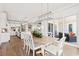 Bright dining area with modern light fixture, table centerpiece, and view to patio with sliding glass door at 109 Serenity Point Dr., Little River, SC 29566