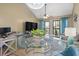 Inviting living space boasts large glass table, modern décor, and a seamless flow to the outdoor balcony at 1100 Possum Trot Rd. # C-203, North Myrtle Beach, SC 29582