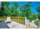 Wooden deck with seating overlooking green lawn and trees, with a paved walkway leading to the home at 112 Blue Gull Dr., Conway, SC 29526