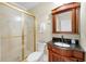 Well-lit bathroom featuring a dark wood vanity, granite top, and a shower behind a glass door at 113 Trotter Trail, Georgetown, SC 29440