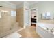 Bright bathroom featuring a large bathtub, walk-in shower, and doorway to the main bedroom at 113 Trotter Trail, Georgetown, SC 29440