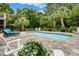 Beautiful backyard pool area with lush tropical landscaping and ample seating at 113 Trotter Trail, Georgetown, SC 29440