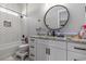 Bright bathroom features a tub and shower, a granite countertop, and a framed, round mirror at 1131 East Isle Of Palms, Myrtle Beach, SC 29579