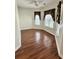 Well-lit living room featuring beautiful hardwood floors and two sunny windows with blinds at 118 Retreat Pl., Little River, SC 29566