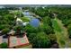 Scenic aerial view of a golf course community featuring a pool, tennis courts, and lush landscaping at 1416 Whistling Straits Way, Sunset Beach, NC 28468