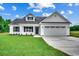 Charming home with a two-car garage, manicured lawn, and lush green surroundings at 142 Temple Dr., Aynor, SC 29511